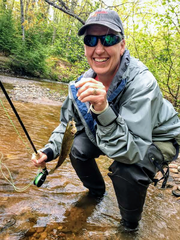 Person with fresh catch during fly fishing trip.