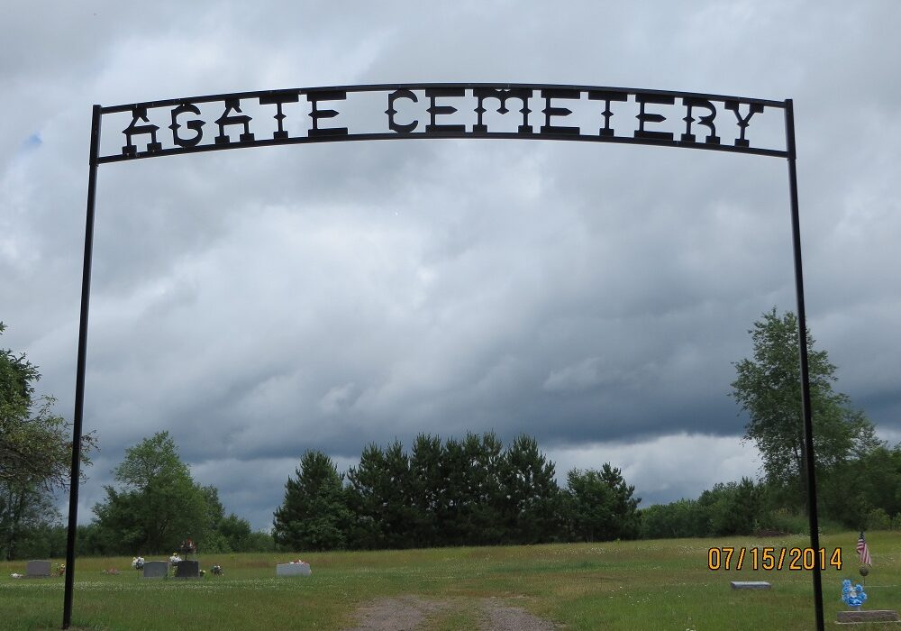 Agate Cemetery entrance sign under cloudy skies