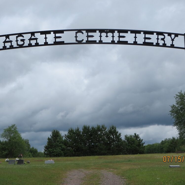 Agate Cemetery entrance sign under cloudy skies