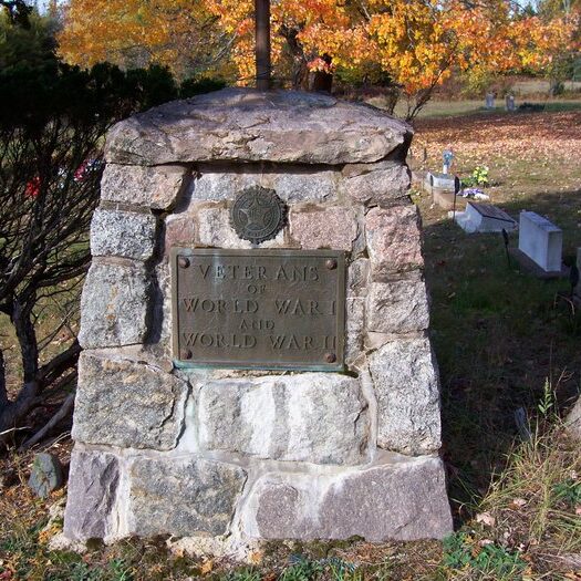 Veterans memorial for WWI and WWII in autumn cemetery.